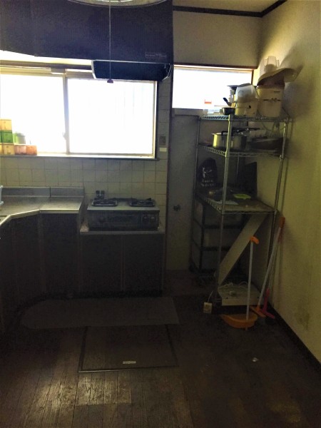 山武市の戸建物件。リフォーム前のキッチンの床は板張りで、壁紙も汚れが。このままでは入居者はつきにくい。