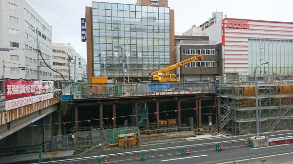 「箕面船場阪大前駅」の工事現場。左手の橋に新駅開業を知らせる幕がかかっている