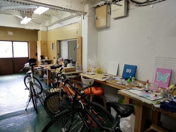工房スペース。イラストなどを描くアーティストや、バイクの修理・改造・販売をする人などが使っている。普段使いの自転車置き場も兼用に。