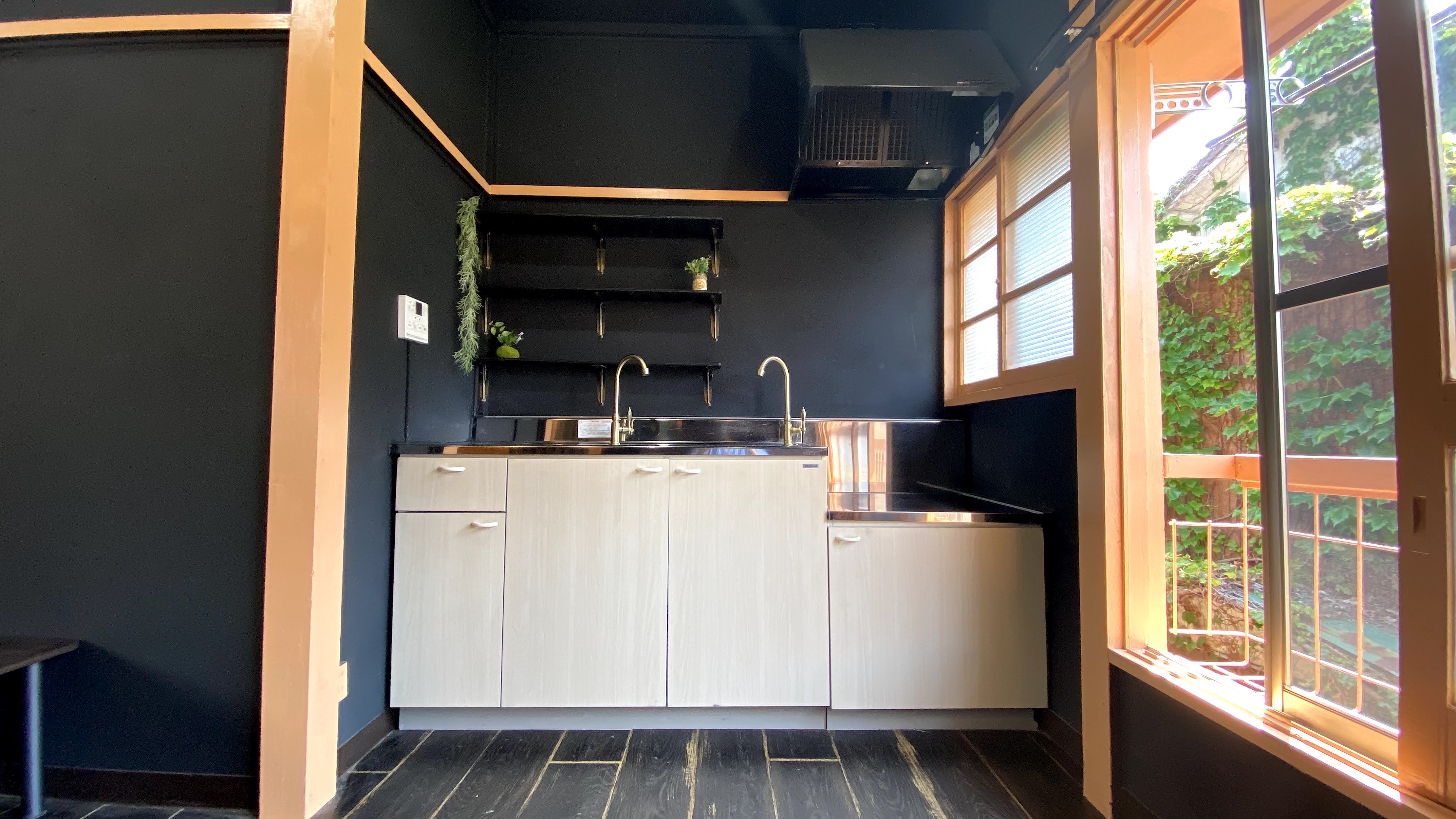 キッチン。壁の黒と建具類のオレンジが印象的