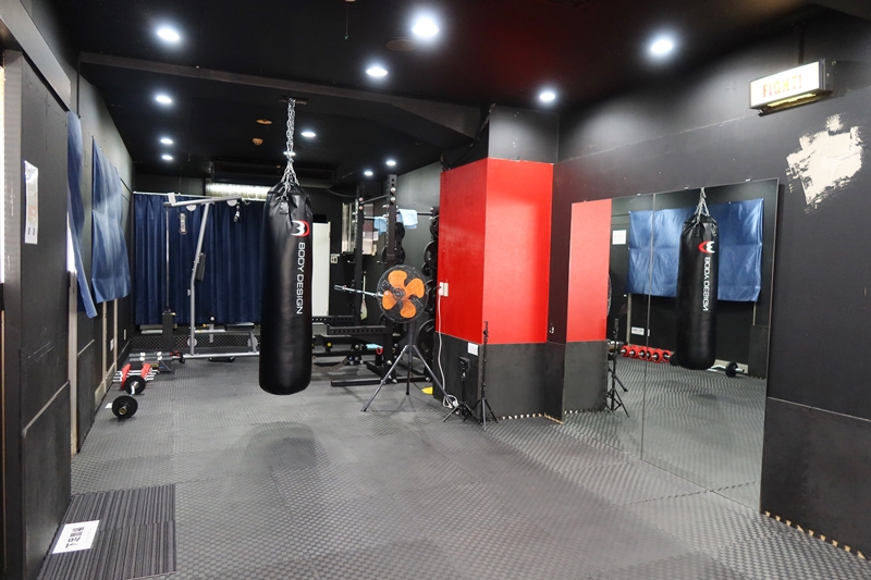 店内内部。手前の半分が格闘技等に使えるスペースで奥にマシンが置かれている。青いカーテンの向こうが脱衣スペース